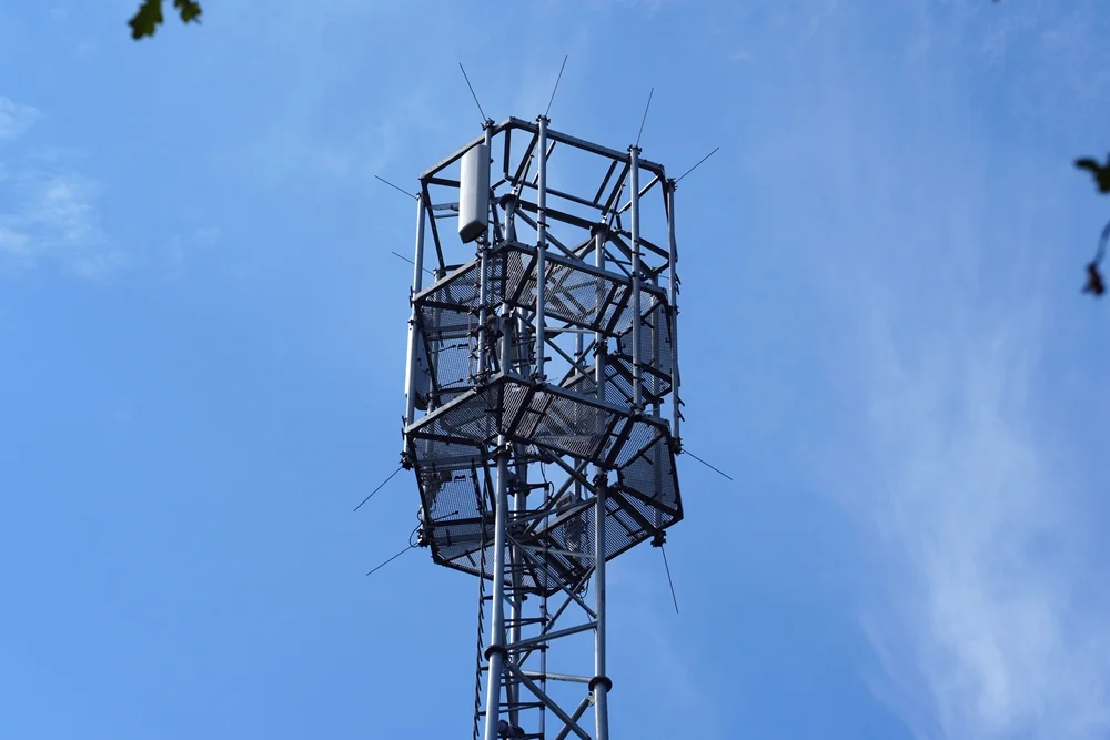 Antennenkopf eines Mobilfunk-Sendemastes mit Sektorantennen und Wartungsplattformen.