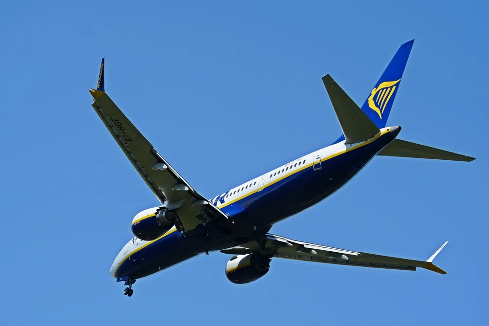 Ryanair-Flugzeug mit ausgefahrenem Fahrwerk kurz vor der Landung am Flughafen Weeze. Die Aufnahme zeigt die Maschine aus nächster Nähe von unten.