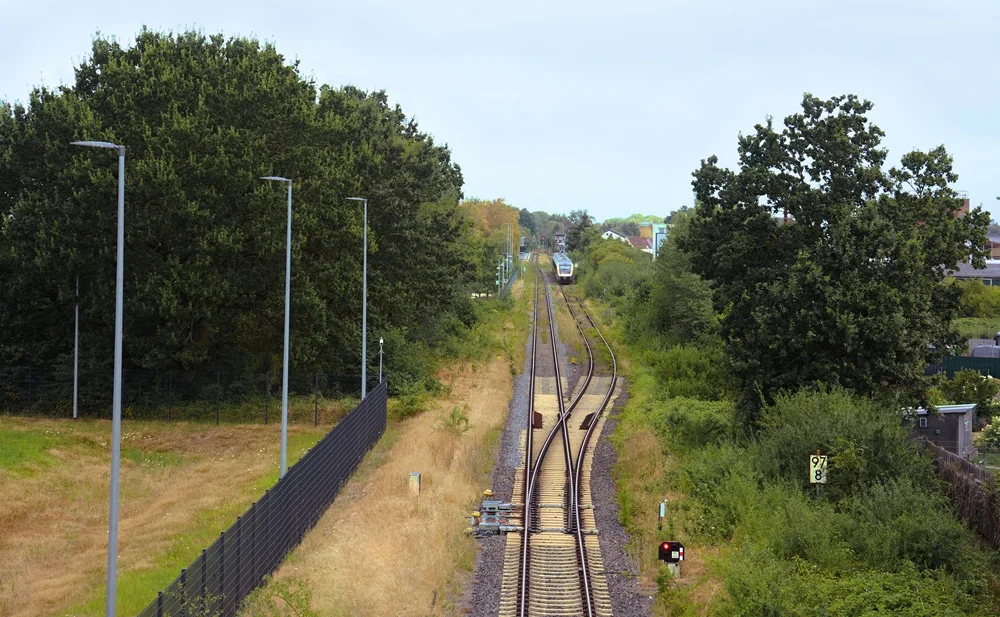 Blick von einer Brücke auf die Bahnstrecke und den Bahnhof Weeze.