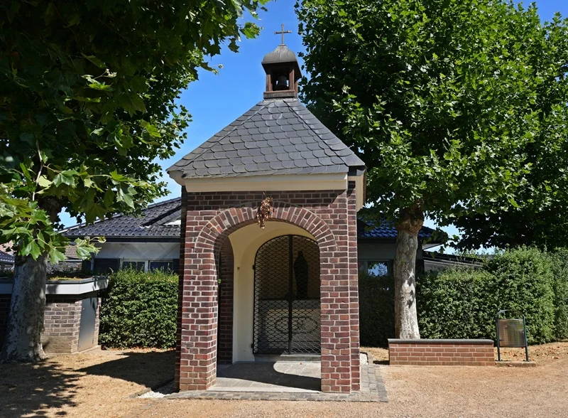 Sent-Jan-Kapelle in Weeze mit Backsteinfassade, umgeben von Bäumen und Grünanlage