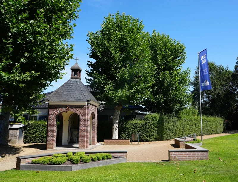 Sent-Jan-Kapelle in Weeze mit Backsteinfassade, umgeben von Bäumen und Grünanlage
