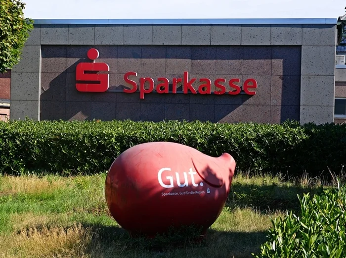 Großes rotes Sparschwein vor der Sparkasse in Weeze