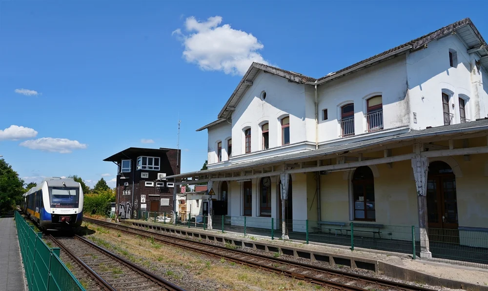 Bahnhof Weeze mit historischem Bahnhofsgebäude, altem Stellwerk und einfahrendem Zug