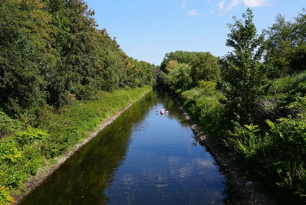 Paddler auf der Niers bei Weeze, umgeben von dichtem Grün und Bäumen