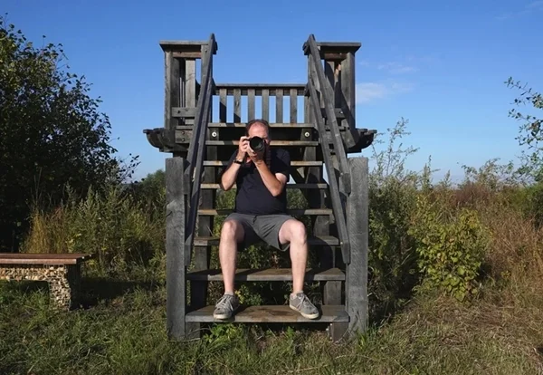 Fotograf mit Kamera auf einer hölzernen Aussichtstreppe in Weeze