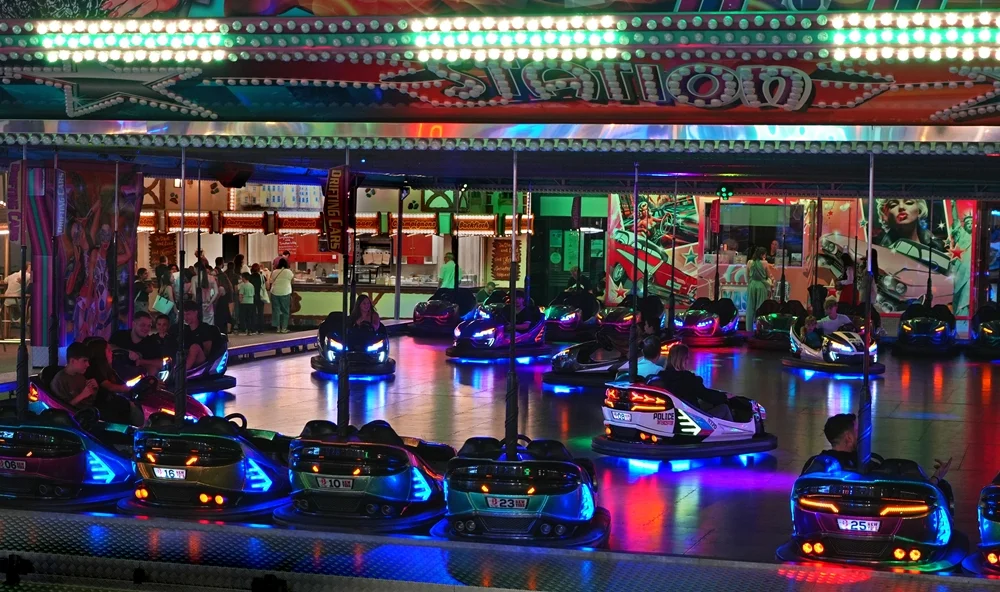 Fahrende Autoscooter mit bunter Beleuchtung am Abend auf der Weezer Kirmes