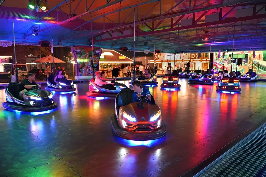 Autoscooter bei Nacht mit bunten Lichtreflexen auf der Fahrbahn auf der Weezer Kirmes