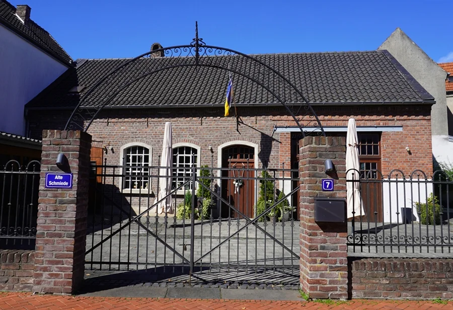 Alte Schmiede in Weeze mit historischem Backsteingebäude und schmiedeeisernem Eingangstor