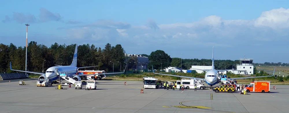 Zwei Flugzeuge von Enter Air auf dem Vorfeld des Airport Weeze mit Service- und Einsatzfahrzeugen.