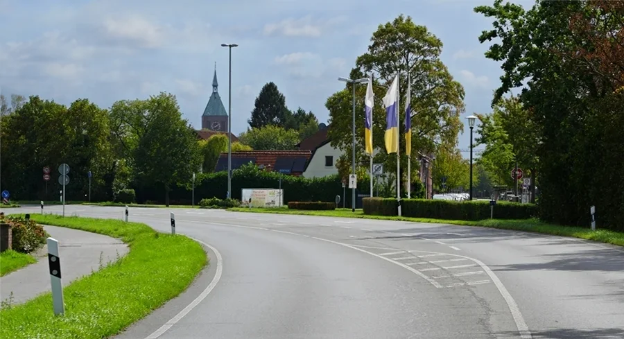 Ortseinfahrt von Weeze aus Richtung Goch über die B9 mit Kirchturm und Weeze-Fahnen