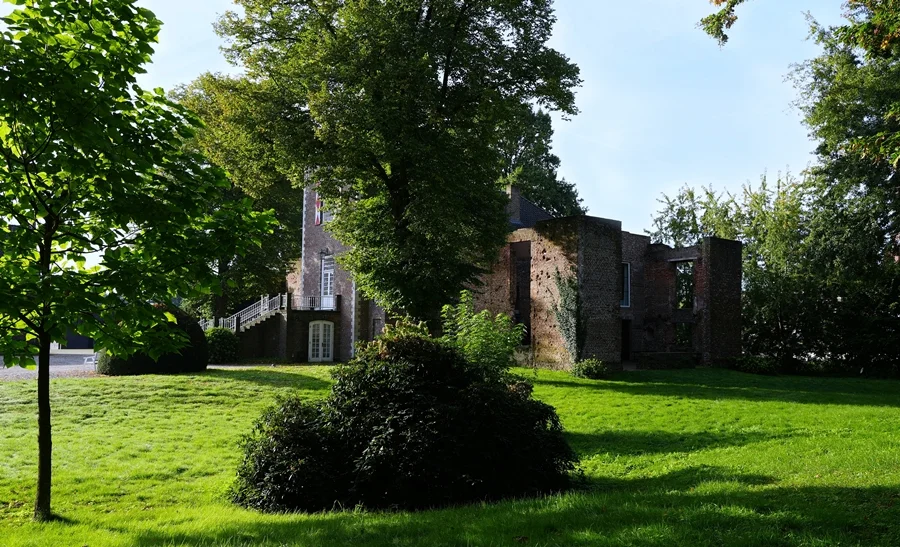 Schloss Hertefeld in Weeze mit Parkanlage, wiederaufgebautem Gebäudeteil und erhaltenen Mauerresten der Schlossruine.