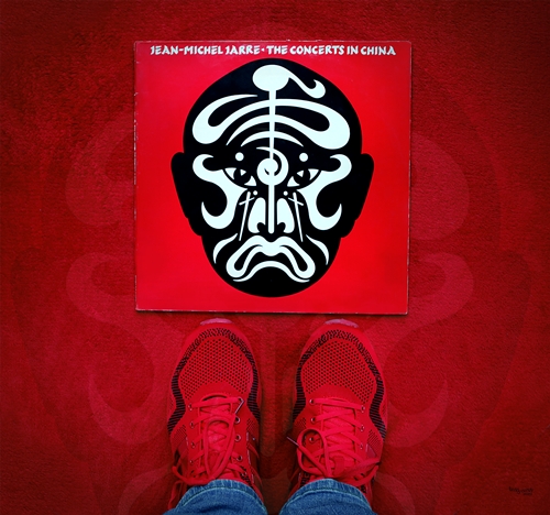 Rote Turnschuhe vor der Schallplatte „The Concerts in China“ von Jean-Michel Jarre. Das Fan-Art-Bild von teddynash spielt mit der Idee einer Reise nach China.