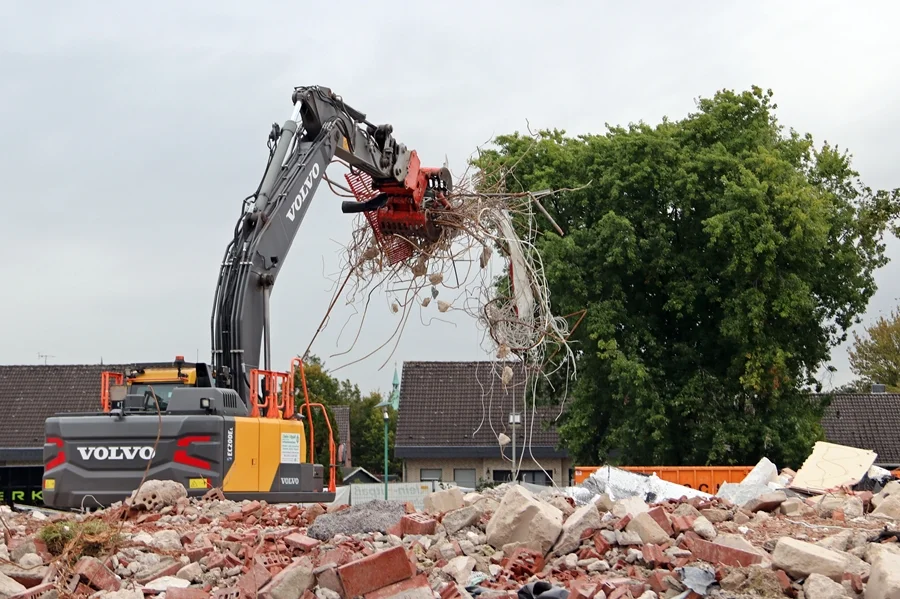 Bagger transportiert Metallschrott vom Schulgelände in Weeze