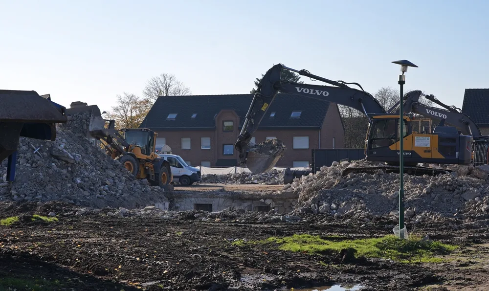 Bagger und Radlader räumen Schutt und legen alte Kellerbereiche auf dem Gelände der Johannes-Hauptschule in Weeze frei