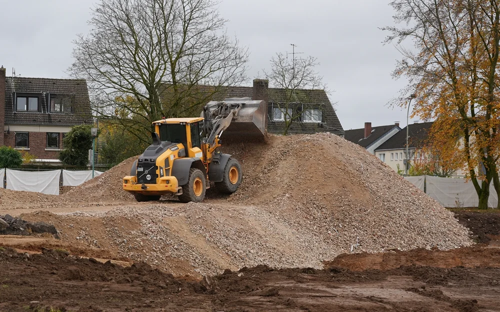 Ein großer Volvo-Radlader verteilt auf der Baustelle recycelten Bauschutt, der später als neues Untergrundmaterial genutzt wird.