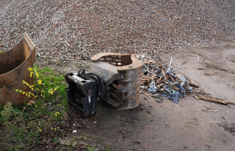 Zwischen Schutt und Kabelresten liegt ein massiver Baggeraufsatz am Rand des ehemaligen Schulgeländes in Weeze.