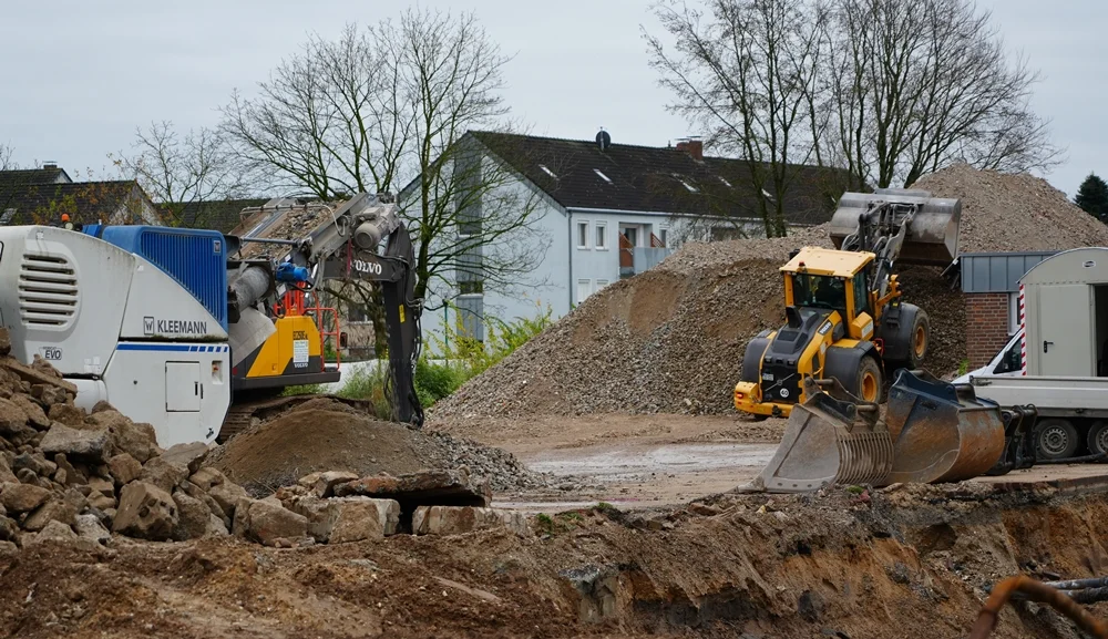 Auf der Baustelle in Weeze werden Beton- und Steinreste der alten Schule zu neuem Recyclingmaterial verarbeitet und zu großen Bergen aufgeschüttet.
