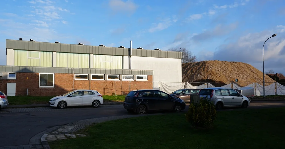Vom Drosselweg aus sieht man die alte Turnhalle der Johannes-Hauptschule und den riesigen Recyclingberg des Schulabbruchs in Weeze.