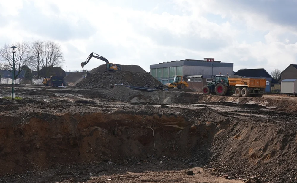 Weitwinkelaufnahme der letzten großen Abrissarbeiten auf dem Gelände der ehemaligen Johannes-Hauptschule in Weeze mit Baggern, Lastwagen und tiefen Baugruben.