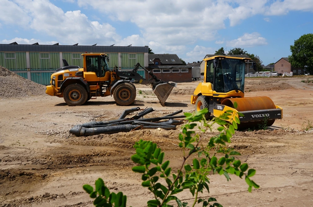 Radlader und Walze stehen auf der freien Baufläche der ehemaligen Hauptschule in Weeze bereit für die nächsten Arbeiten.