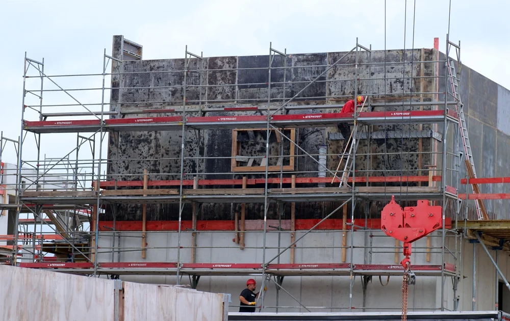 Bauarbeiter auf einem Gerüst arbeiten an der Schalung des Obergeschosses der neuen Petrus-Canisius-Grundschule in Weeze. Ende Juli 2026