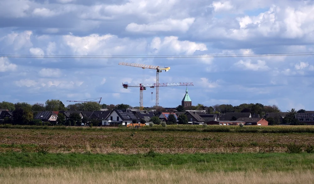 Blick über Weeze mit mehreren Baukränen und dem Kirchturm von St. Cyriakus
