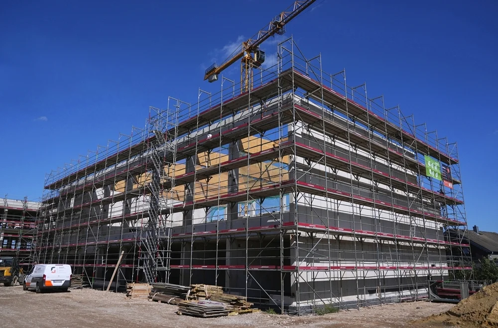 Eingerüsteter Neubau der Petrus-Canisius-Grundschule mit den neu montierten Dachbalken der Sporthalle