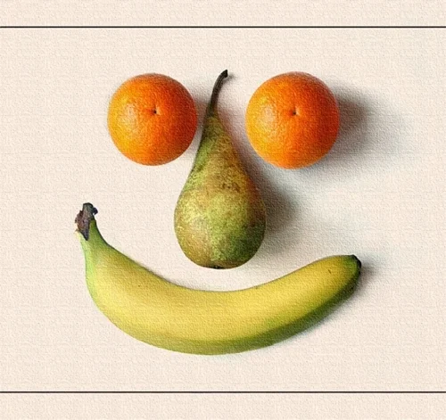 Aus einer Banane, einer Birne und zwei Mandarinen entsteht ein lächelndes Gesicht. Die einfache Komposition verwandelt Obst in eine freundliche Figur.